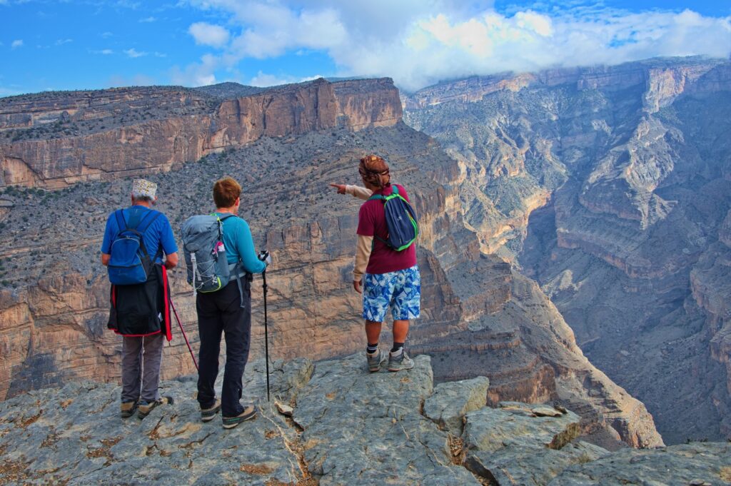 Senior couple and their guide standing at the edge of canyon